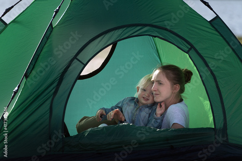 Mom and baby in big tourist tent. Camping with children. Vacation