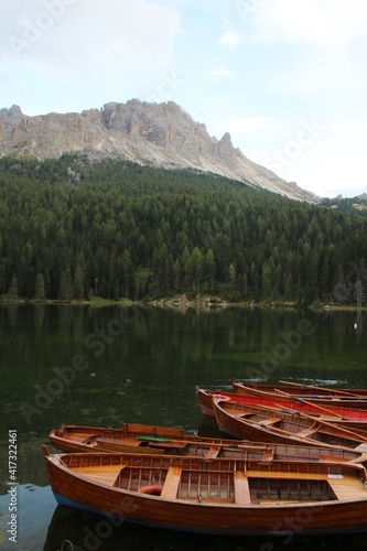 Holzruderboote auf einem See mit Bergen und Bäumen im Hintergrund  © johannes81