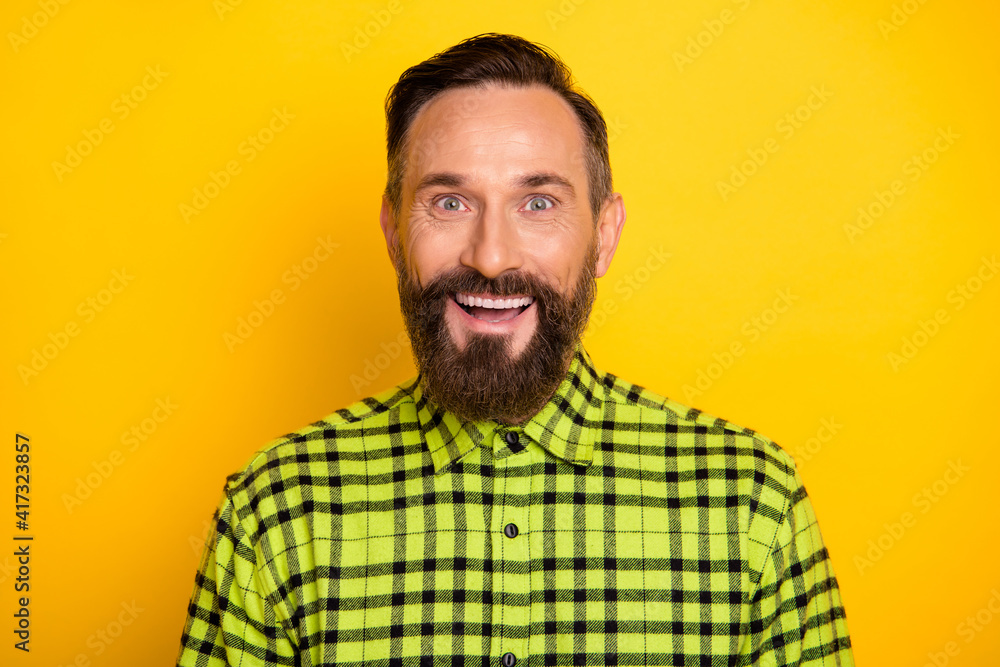 Portrait of attractive cheerful lucky man wearing checked shirt isolated over bright yellow color background Portrait of attractive cheerful lucky man wearing checked shirt isolated over bright yellow color background