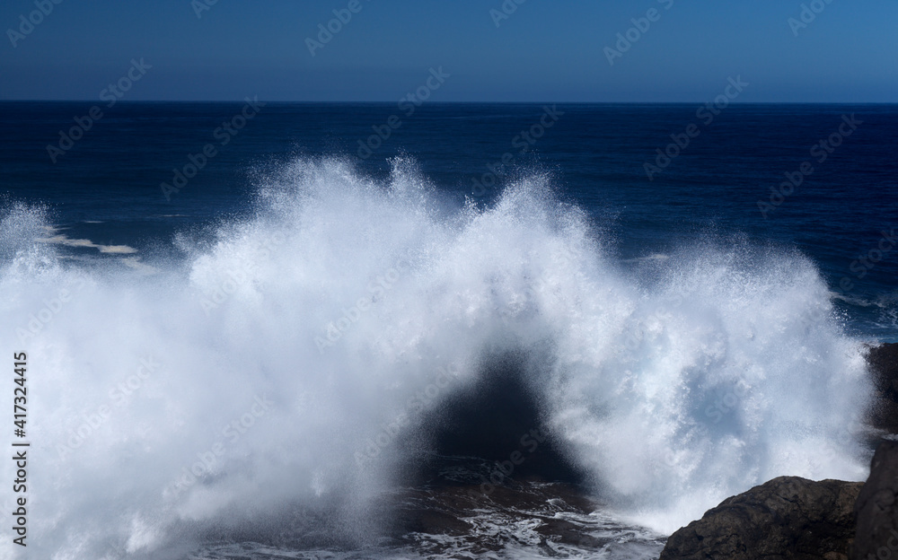 Gran Canaria, north coast, area around Punta Sardina cape, powerful foamy ocean waves breaking along the shore

