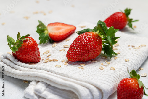 Juicy strawberries on a white background. Scattered oatmeal. Healthy lifestyle.