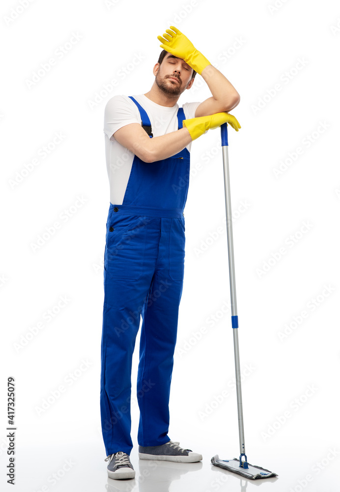 profession, service and people - tired male worker or cleaner in overal and gloves cleaning floor with mop over white background profession, service and people - tired male worker or cleaner in overal and gloves cleaning floor with mop over white background