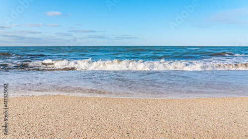 Fototapeta Naklejka Na Ścianę i Meble -  Empty beach with yellow sand and blue waves, quarantine at the resort