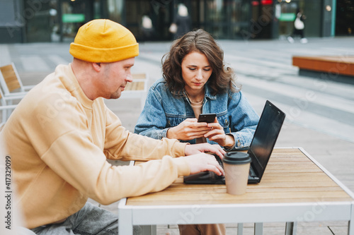 Stylish young couple freelancers working on laptop in the street cafe © Galina Zhigalova