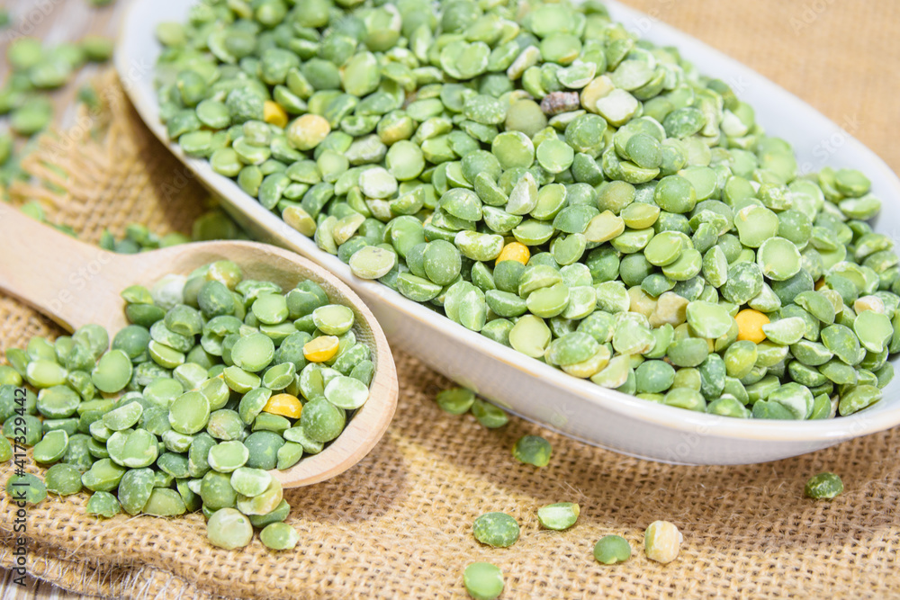 Dry green peas in a bowl. Peas as a natural product and healthy food. Peas, spoon, burlap, saucer. Dry green peas in a bowl. Peas as a natural product and healthy food. Peas, spoon, burlap, saucer.
