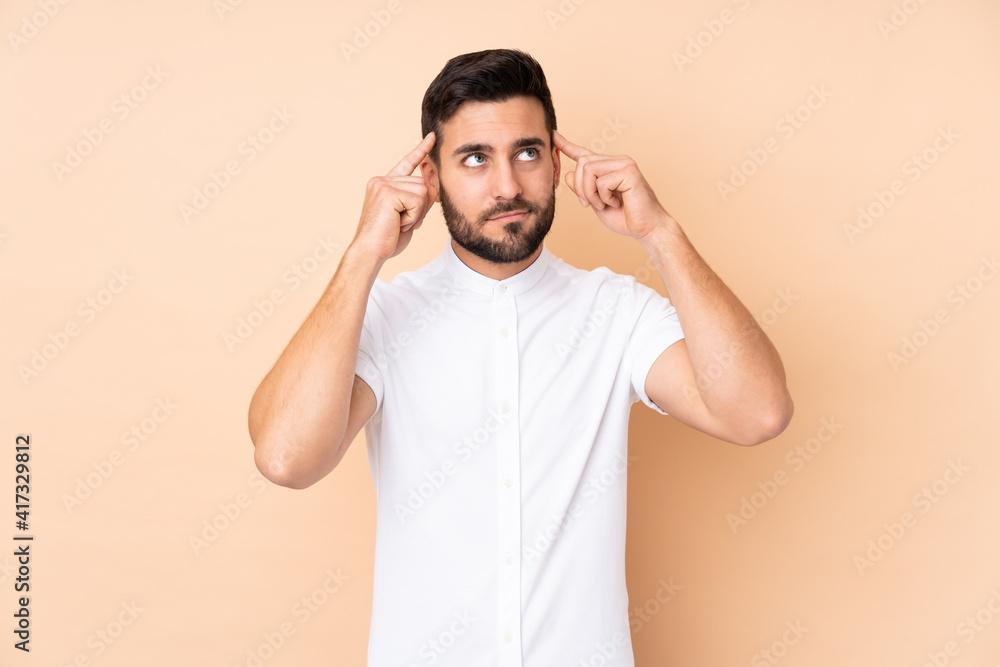 Caucasian handsome man isolated on beige background having doubts and thinking Caucasian handsome man isolated on beige background having doubts and thinking