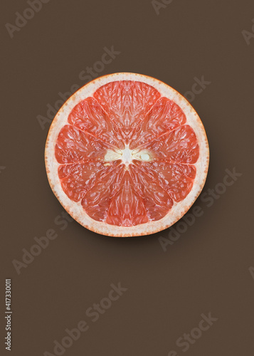 Slice of pink grapefruit on grey background photo