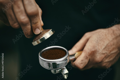 Close-up holding bottomless portafilter before making fresh coffee
