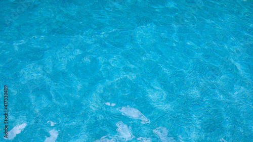 Abstract pool water.  Swimming pool bottom caustics ripple and flow with waves background surface of blue swimming pool © Charlie's