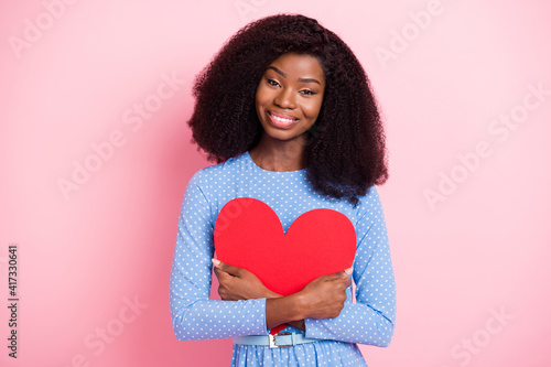 Photo of lady embrace big red paper heart figure wear blue dotted dress isolated pink color background