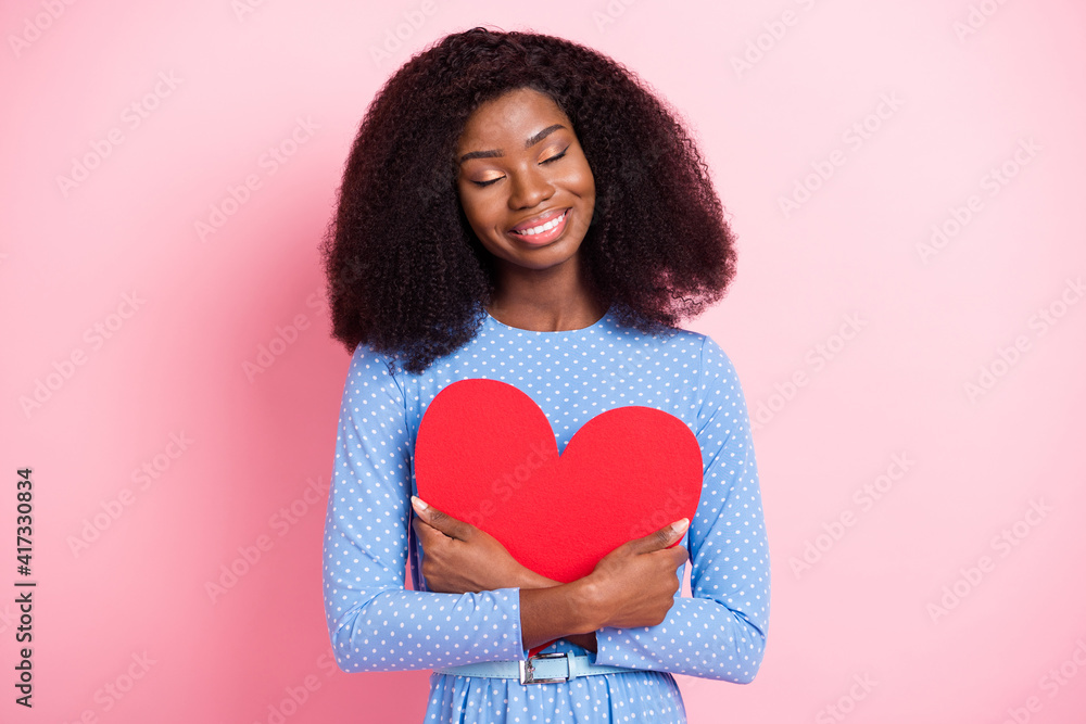 Photo of lady hug red paper heart close eyes toothy smile wear blue dotted dress isolated pink color background Photo of lady hug red paper heart close eyes toothy smile wear blue dotted dress isolated pink color background