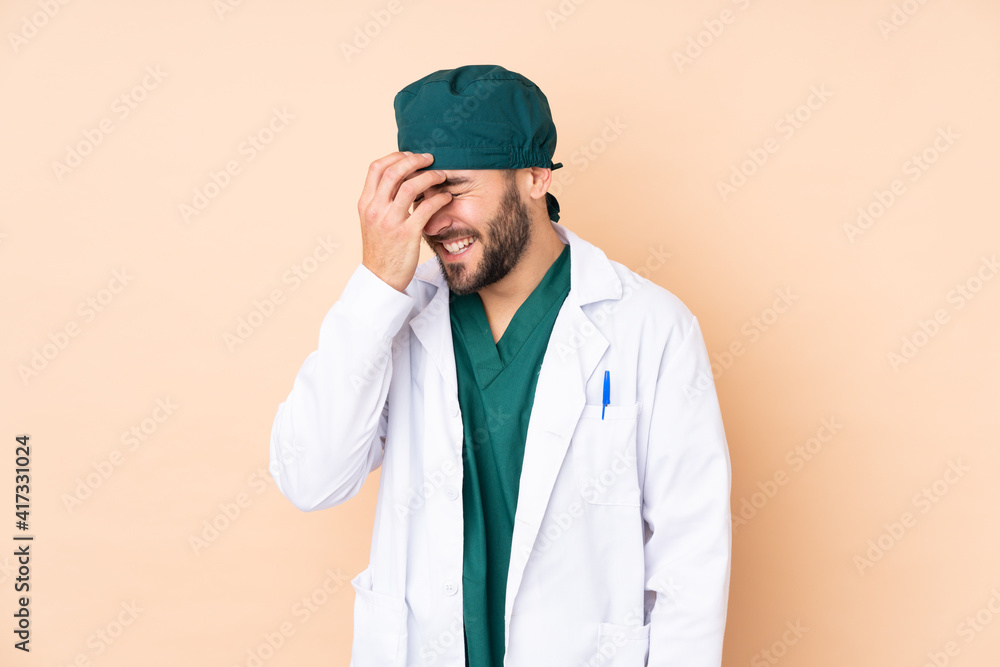 Surgeon man isolated on beige background laughing Surgeon man isolated on beige background laughing