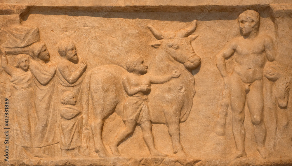 Votive relief Panis Aigirios to Heracles, form of a naiskos, from the sanctuary of Heracles at Kynosarges in Athens, Greece. Heracles is depicted at the right holding the lions pelt. 4th century B.C.