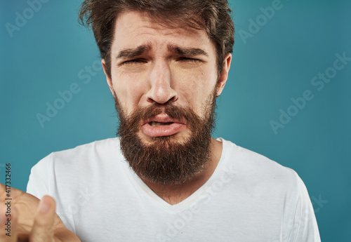 Man with upset face on blue background cropped view portrait