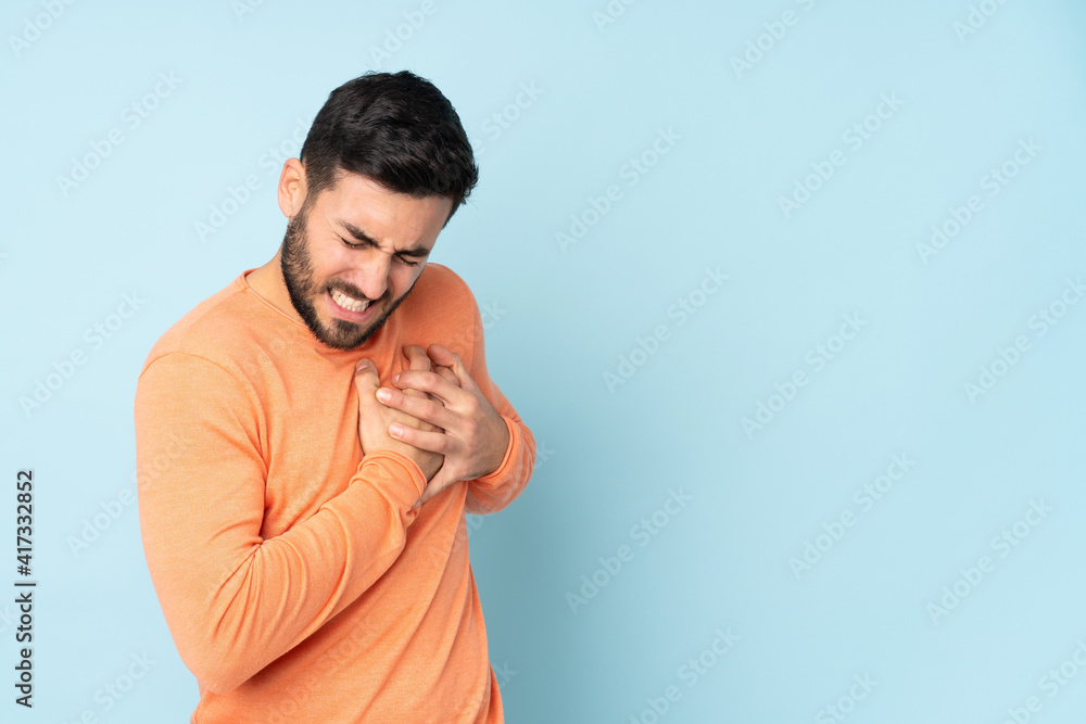 Caucasian handsome man having a pain in the heart over isolated blue background Caucasian handsome man having a pain in the heart over isolated blue background
