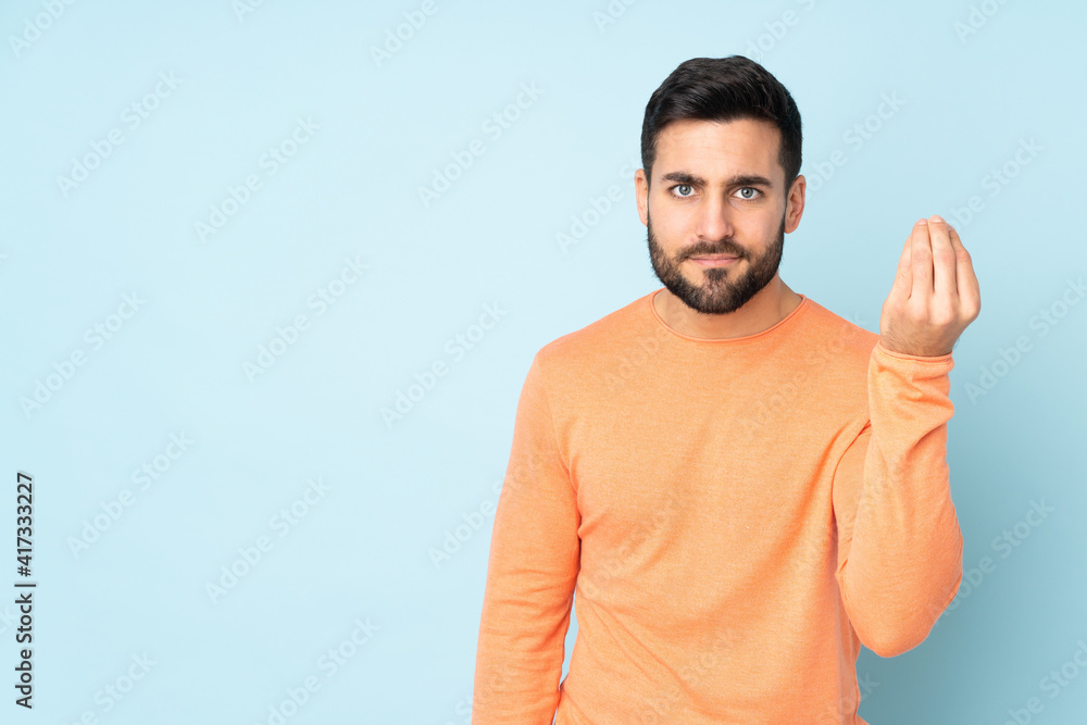 Fototapeta premium Caucasian handsome man making Italian gesture over isolated blue background