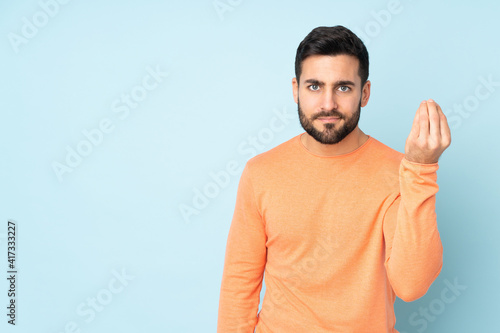 Caucasian handsome man making Italian gesture over isolated blue background