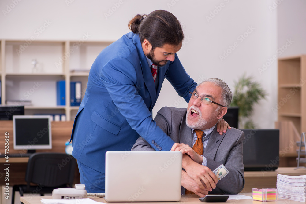 Old male boss and young male employee in remuneration concept Old male boss and young male employee in remuneration concept