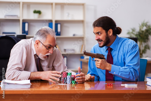 Two male employees playing cards at workplace