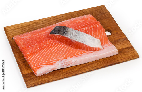 Large and small pieces of salmon fillet on cutting board