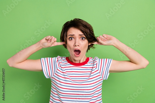 Obraz na plátně Portrait of pretty desperate girl closing ears unpleasant noise isolated over gr