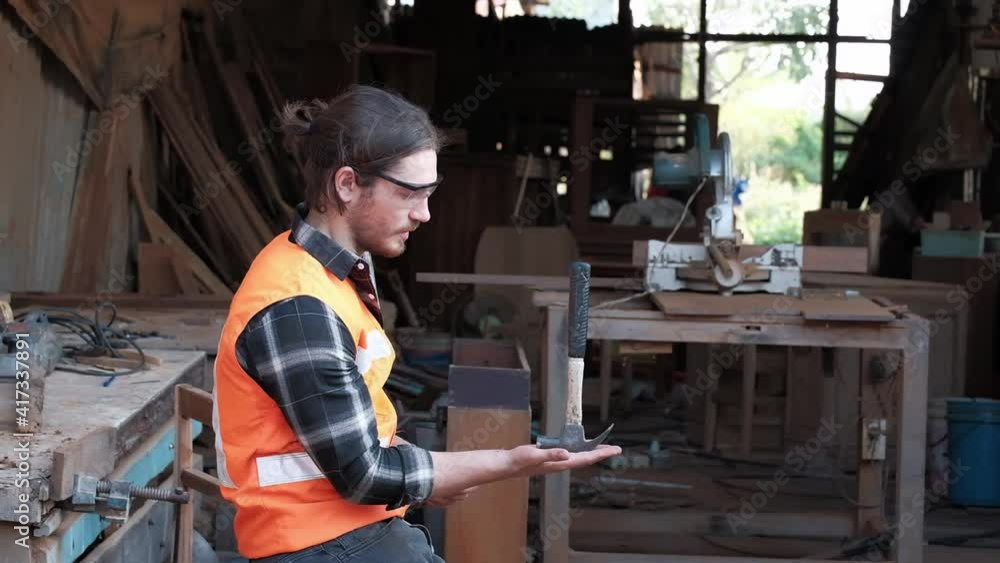 A young carpenter is working to order in his own wood factory. With peace of mind by using hand tools including saws, wood planers, hammers, and more. A young carpenter is working to order in his own wood factory. With peace of mind by using hand tools including saws, wood planers, hammers, and more.