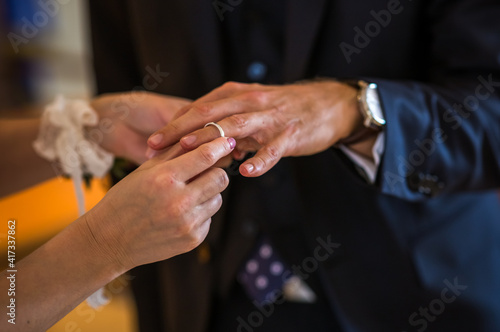 Wedding rings in the hands of the bride and groom. Wearing wedding rings, gentle touches, hands of the bride