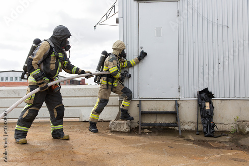 Firefighters holding fire hose photo