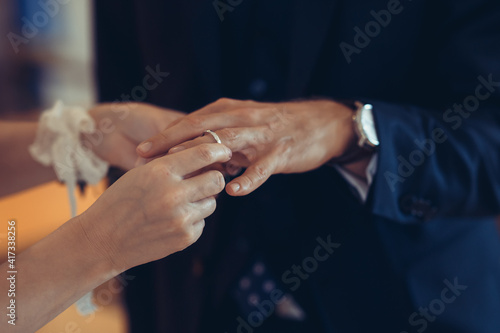 Wedding rings in the hands of the bride and groom. Wearing wedding rings, gentle touches, hands of the bride