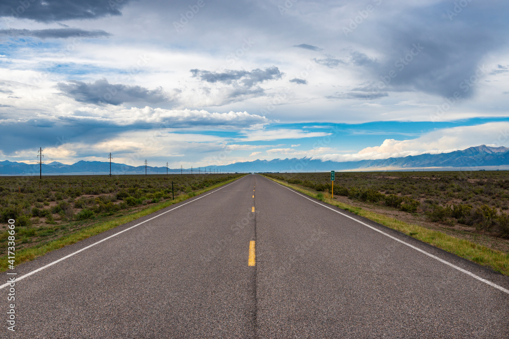 Scenic view of an empty road with mountains on the background, in the State of Colorado, USA; Concept for travel and road trip in the USA