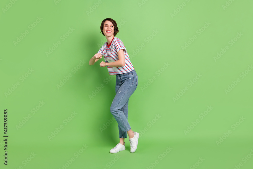Full length body size view of attractive cheerful girl dancing free time rest relax isolated over green pastel color background Full length body size view of attractive cheerful girl dancing free time rest relax isolated over green pastel color background