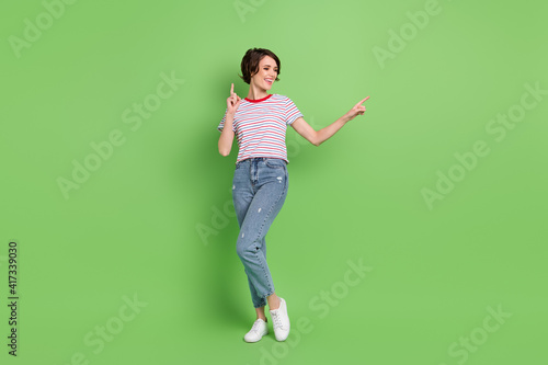 Full length body size view of attractive cheerful girl dancing having fun isolated over green pastel color background