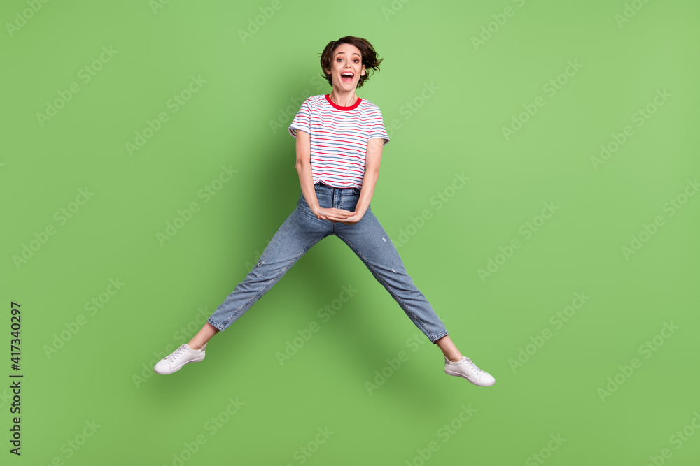 Full length body size view of pretty cheerful funny girl jumping fooling isolated over green pastel color background