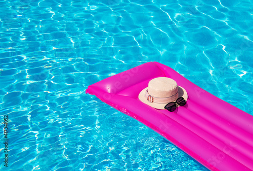 Beach summer holiday background. Inflatable air mattress and hat on swimming pool.;