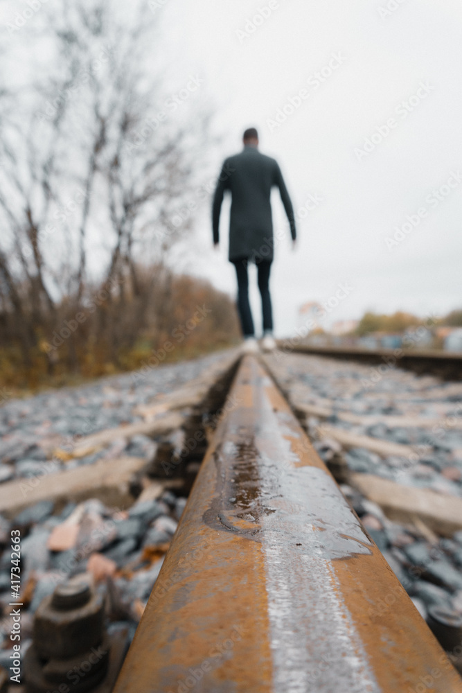 man walking on railroad