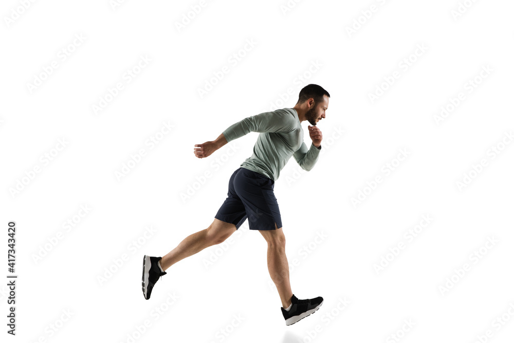 Run. Young caucasian male model in action, motion isolated on white background with copyspace. Concept of sport, movement, energy and dynamic, healthy lifestyle. Training, practicing. Authentic.