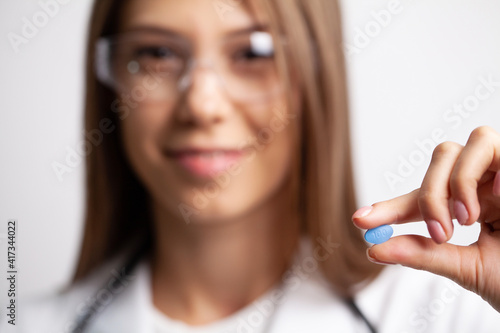 Closeup of female doctor holding pill for men health photo