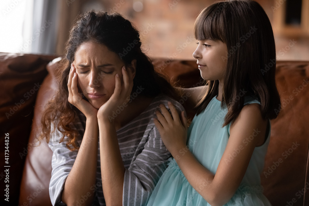 Cute small Hispanic girl kid hug cuddle comfort upset young mother feeling sad unhappy at home. Loving caring Latino little daughter caress support mom, make peace reconcile after family fight. Cute small Hispanic girl kid hug cuddle comfort upset young mother feeling sad unhappy at home. Loving caring Latino little daughter caress support mom, make peace reconcile after family fight.