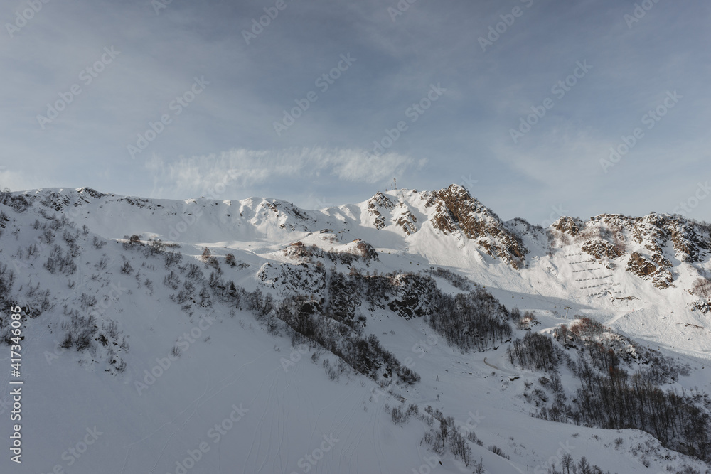 Alpine landscape, slopes of high mountains with glaciers against the blue sky.