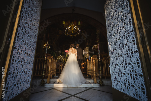 Bride and groom entering in a church in wedding dress