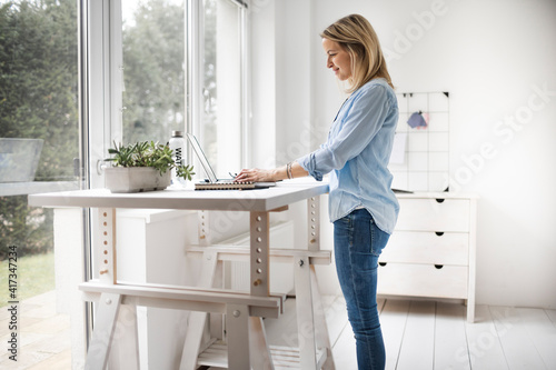 Businesswoman working at ergonomic standing desk. photo