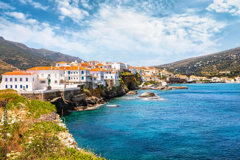 Fototapeta premium Panorama of the beautiful town of Andros island situated on rocks over the Aegean sea, Cyclades, Greece