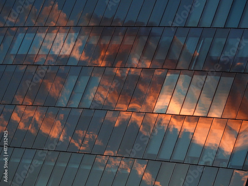 Fotografie architecture of glass building with reflection of sky sunset