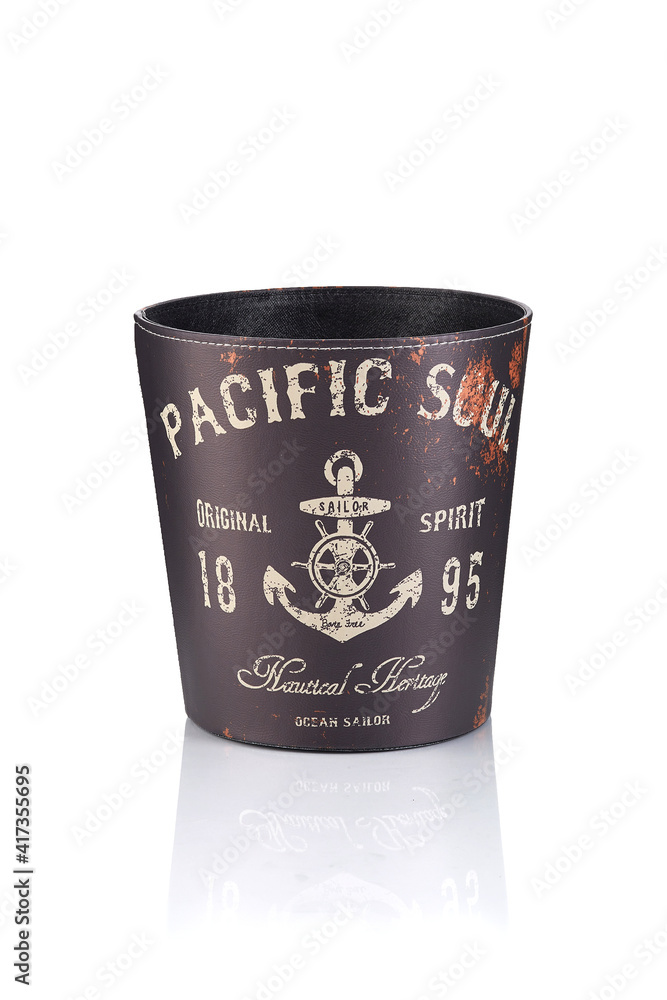 Subject shot of brown leather wastebasket with retro print of nautical