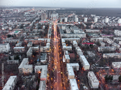 Aerial view Kharkiv city center Nauky avenue. Pavlove Pole and Botanical garden area with multistorey high buildings in evening. Grey winter city with red street lights photo