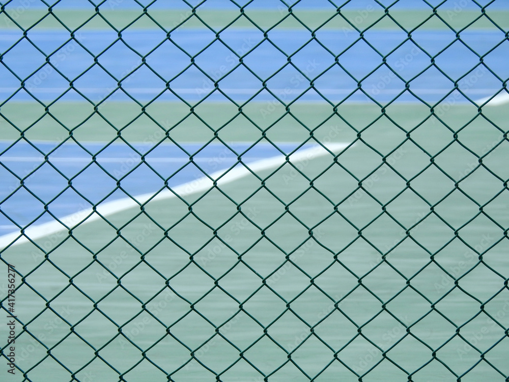 green wire mesh of fence enclose the tennis court green wire mesh of fence enclose the tennis court