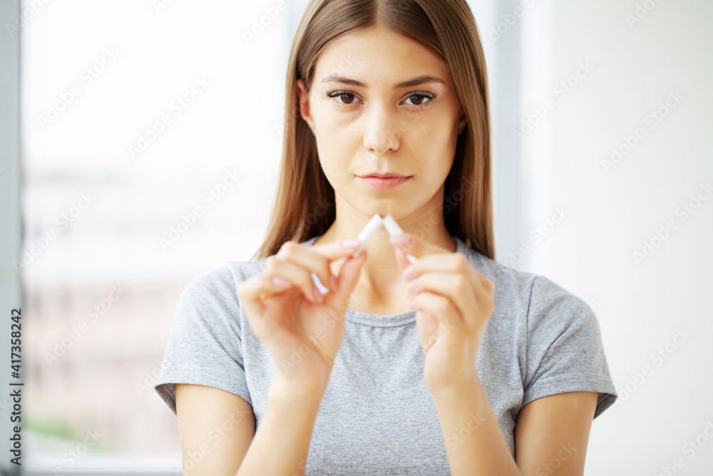 Stop smoking, woman holding a broken cigarette Stop smoking, woman holding a broken cigarette