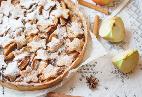 Traditional apple pie on the table with decorations.