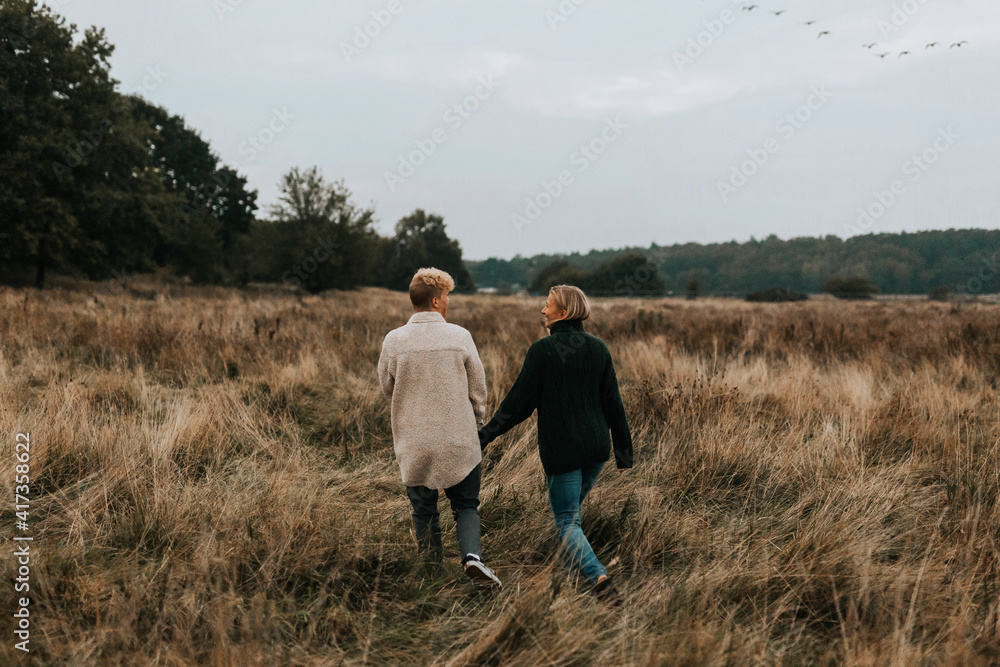 Female couple walking through meadow Female couple walking through meadow