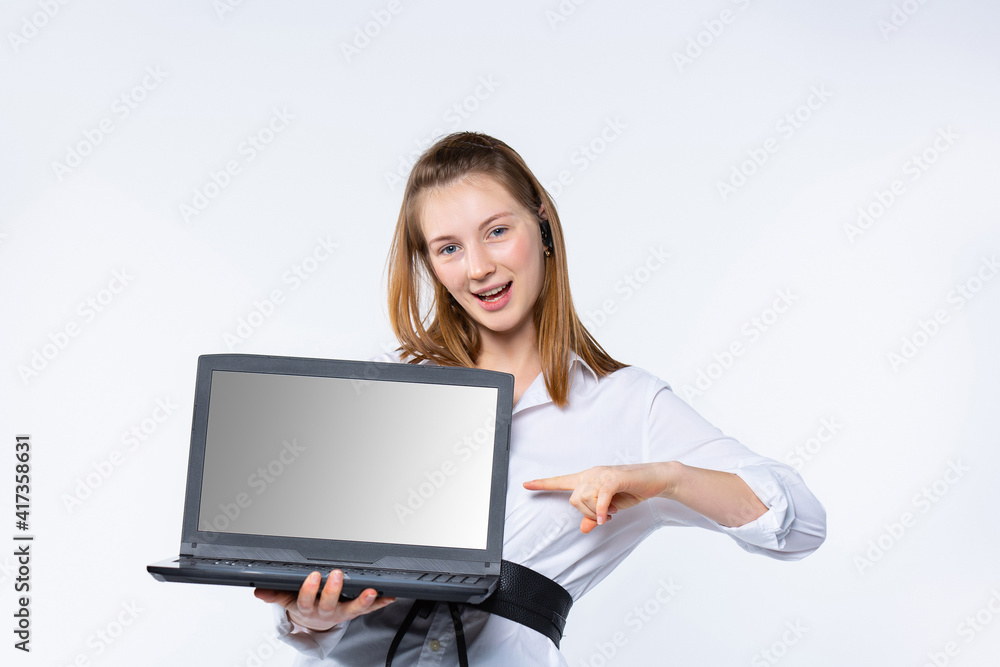 Portrait of a successful business woman with a smile shows a forefinger on a gray laptop screen. White background. Advertising concept. Portrait of a successful business woman with a smile shows a forefinger on a gray laptop screen. White background. Advertising concept.